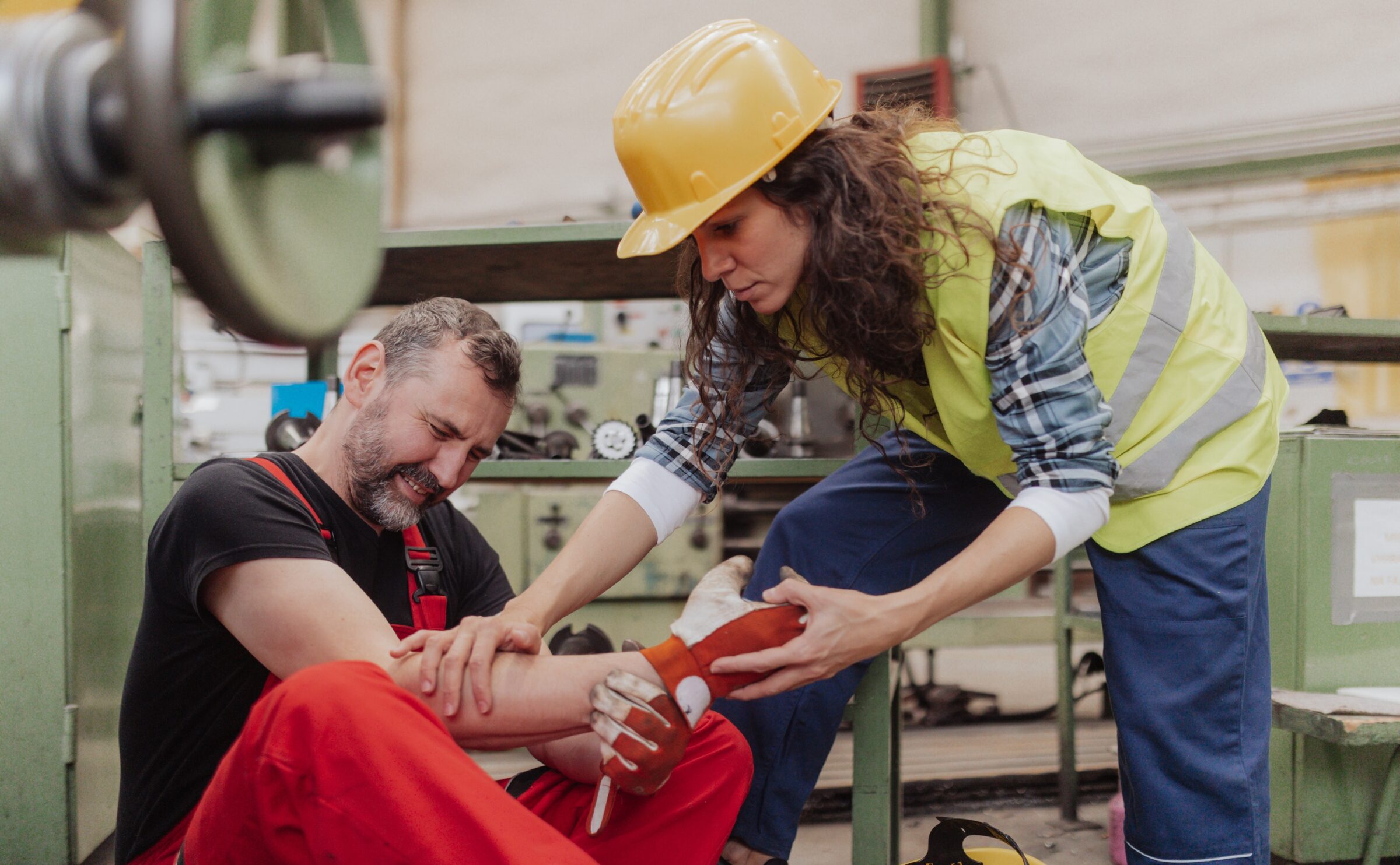 Woman,Is,Helping,Her,Colleague,After,Accident,In,Factory.,First